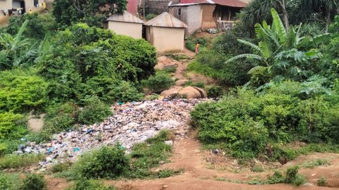 Abuja, Nigeria – Hotone da yake nuna mazauna yanki da yake kewaye da shukokin koraye tare da gidaje da waje mai dauke da bola.A